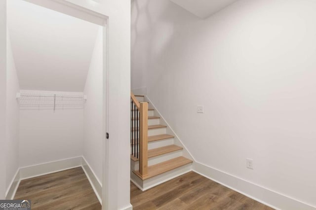 stairs featuring vaulted ceiling and hardwood / wood-style floors