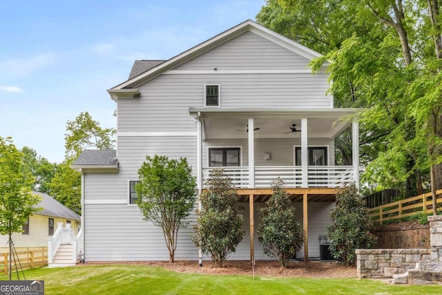 rear view of property featuring ceiling fan, a yard, and a sunroom