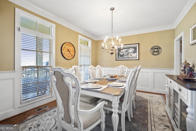 dining room featuring ornamental molding, an inviting chandelier, and dark hardwood / wood-style flooring