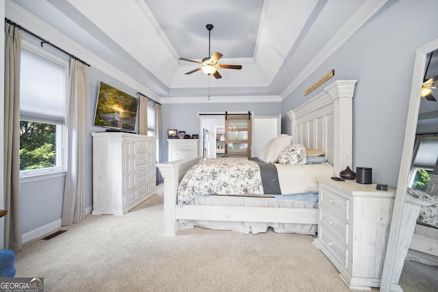 bedroom with crown molding, light colored carpet, a tray ceiling, ceiling fan, and a barn door