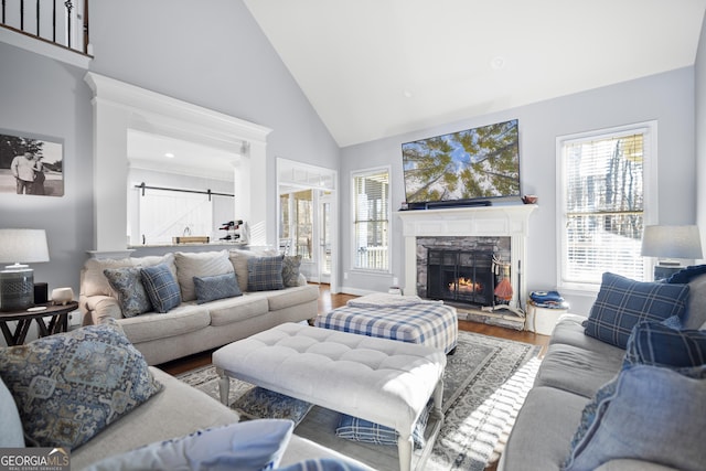 living room featuring hardwood / wood-style flooring, plenty of natural light, a fireplace, and high vaulted ceiling