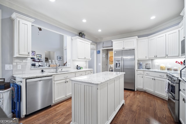 kitchen with stainless steel appliances, a center island, white cabinets, and decorative backsplash