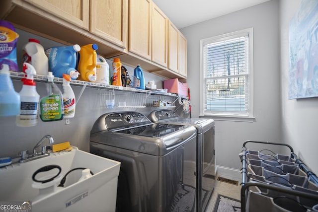 clothes washing area with light tile patterned flooring, cabinets, separate washer and dryer, and sink