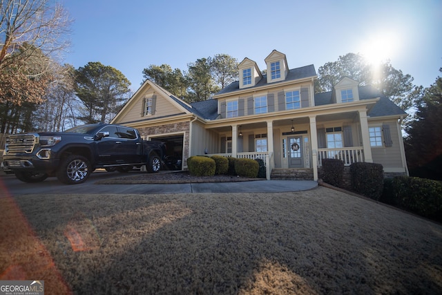 new england style home featuring a garage and covered porch