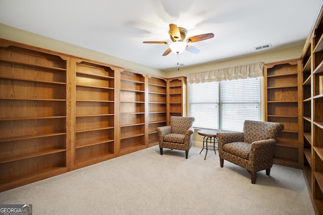 sitting room featuring ceiling fan and light colored carpet