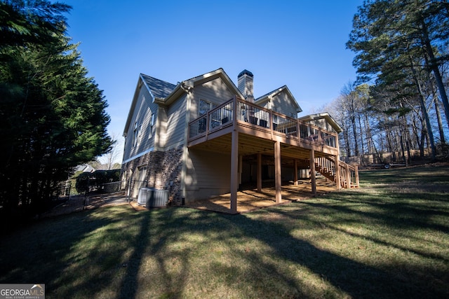 back of property with a wooden deck and a yard