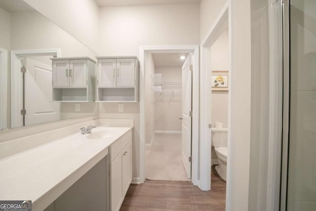 bathroom with hardwood / wood-style floors, toilet, and vanity