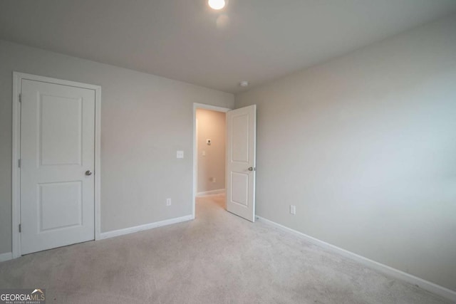 unfurnished bedroom featuring light carpet