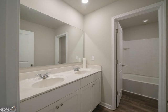 bathroom with hardwood / wood-style flooring, bathtub / shower combination, and vanity