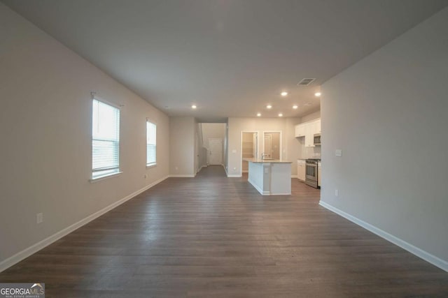 unfurnished living room with dark wood-type flooring