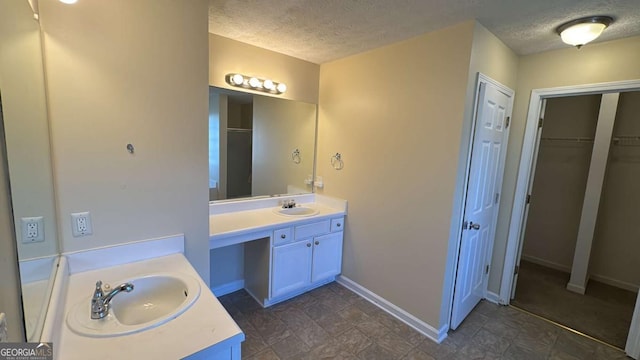 bathroom featuring a shower with door, a textured ceiling, and vanity