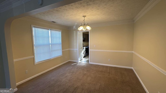 carpeted empty room featuring a textured ceiling, an inviting chandelier, and ornamental molding