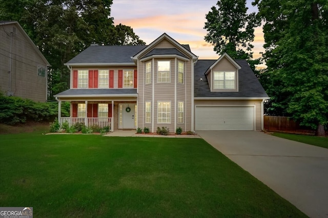 view of front of property featuring covered porch, a garage, and a lawn