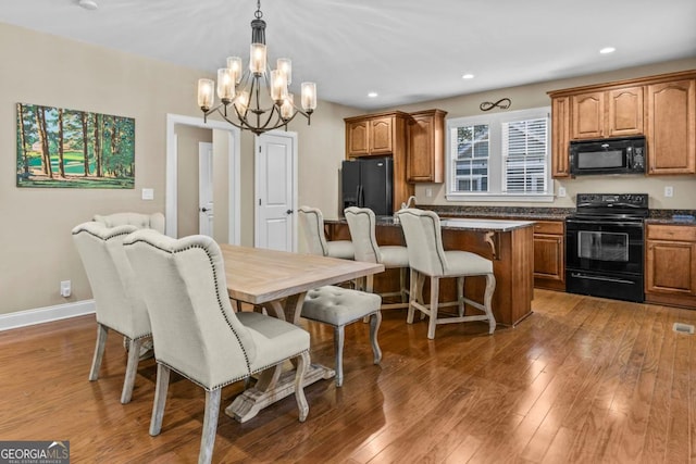 dining space featuring dark wood-type flooring and a chandelier