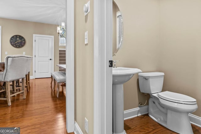 bathroom with toilet, a chandelier, and hardwood / wood-style floors