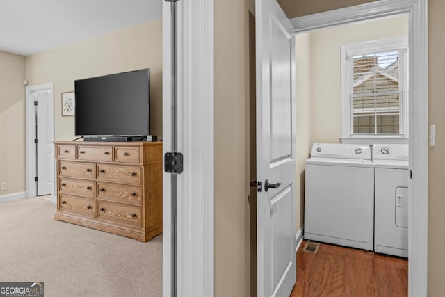 clothes washing area with carpet floors and washer and clothes dryer