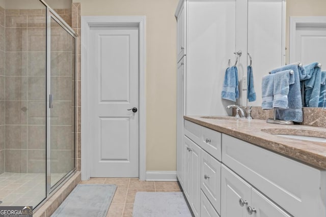 bathroom featuring a shower with shower door, vanity, and tile patterned flooring