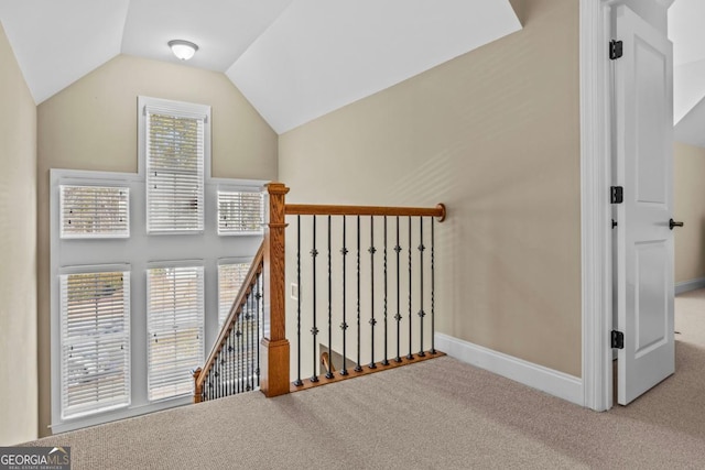 stairway featuring vaulted ceiling and carpet flooring