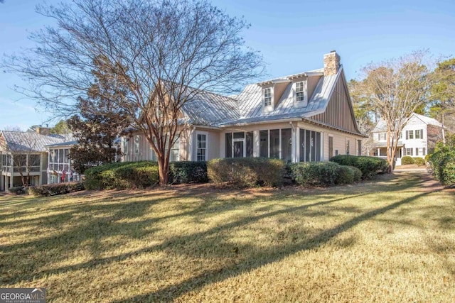 view of property exterior with a sunroom and a lawn