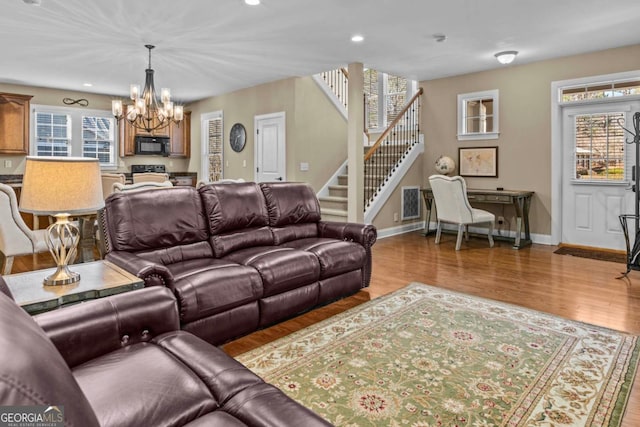 living room featuring light hardwood / wood-style floors and a notable chandelier