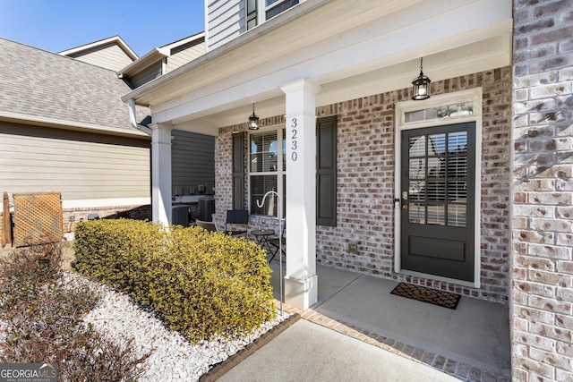 doorway to property featuring covered porch and cooling unit