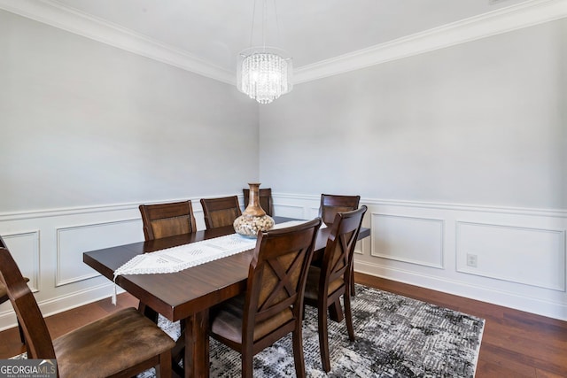 dining area with dark wood-type flooring, an inviting chandelier, and crown molding