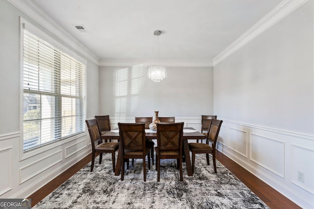 dining room featuring an inviting chandelier, ornamental molding, and dark hardwood / wood-style floors