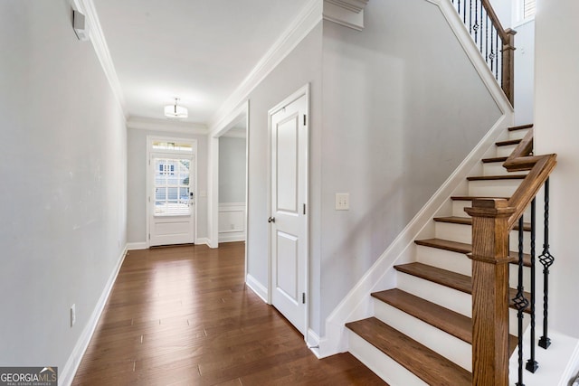 foyer entrance with dark hardwood / wood-style flooring and ornamental molding