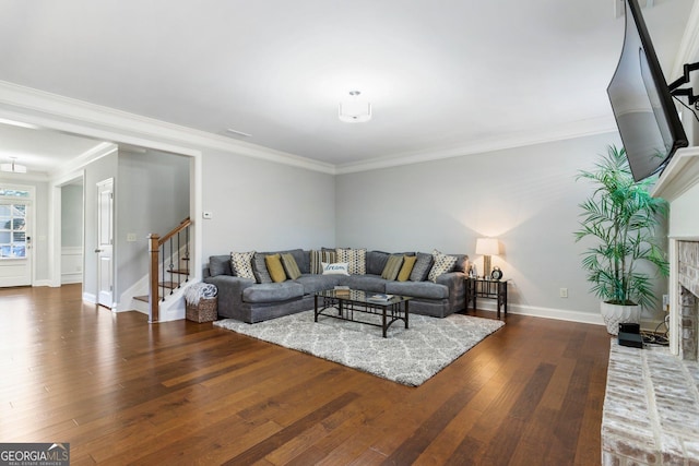 living room with a brick fireplace, dark hardwood / wood-style flooring, and crown molding