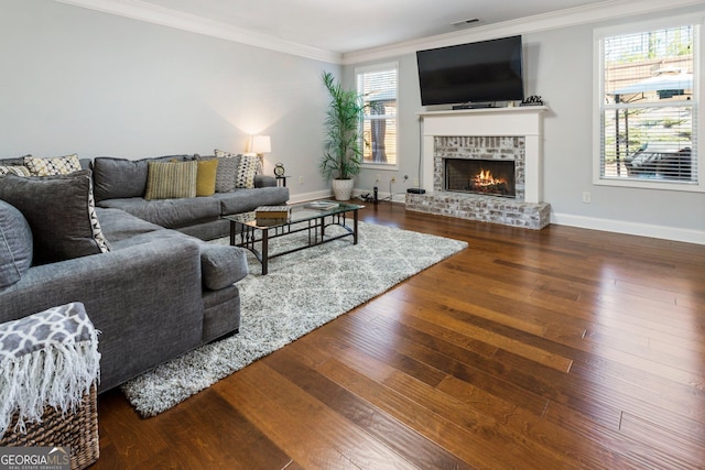 living room with wood-type flooring, a brick fireplace, and crown molding