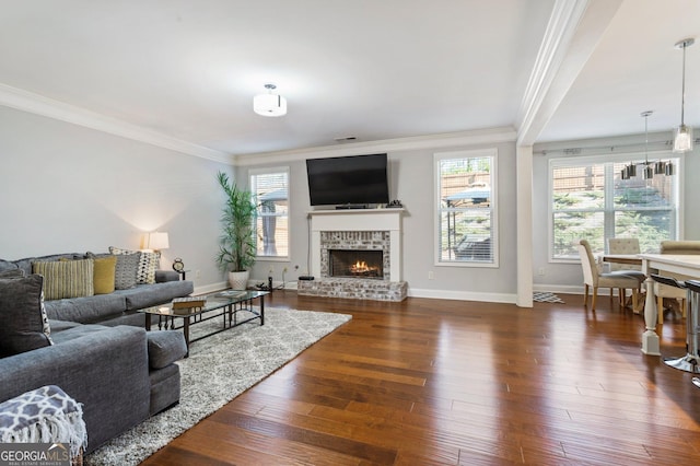 living room featuring a brick fireplace, dark wood-type flooring, and crown molding