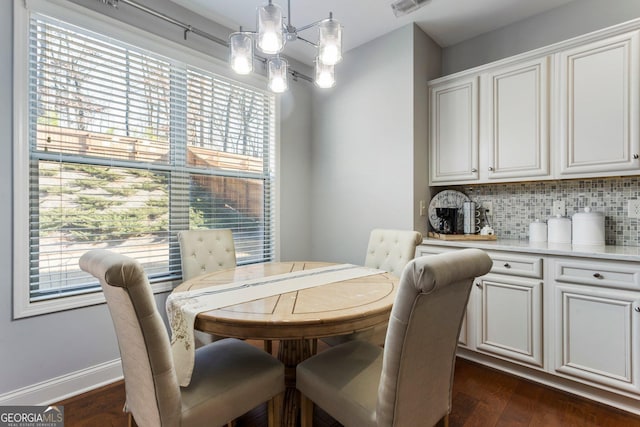 dining room with dark hardwood / wood-style floors and a notable chandelier