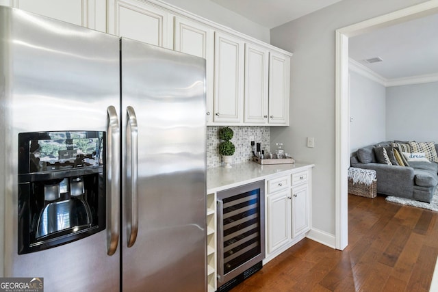 bar featuring backsplash, dark wood-type flooring, white cabinets, stainless steel fridge, and beverage cooler