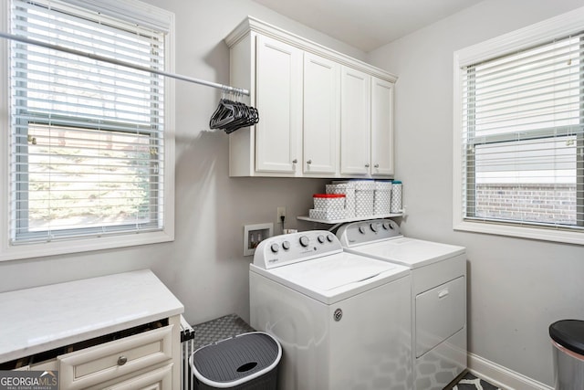 washroom with cabinets and washing machine and clothes dryer