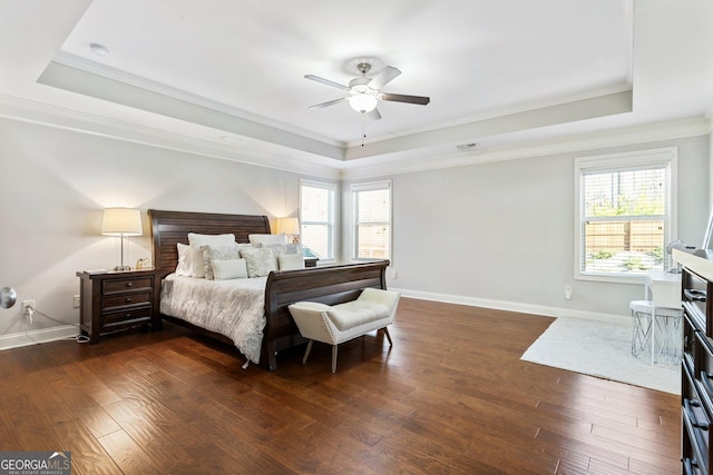 bedroom with ceiling fan, crown molding, dark hardwood / wood-style floors, and a tray ceiling