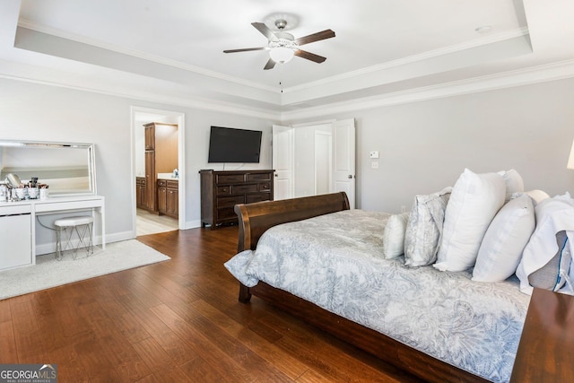 bedroom featuring hardwood / wood-style flooring, ceiling fan, a raised ceiling, ensuite bath, and ornamental molding