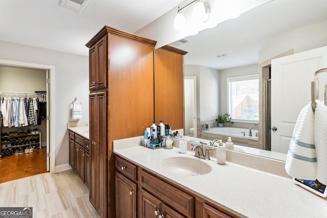 full bathroom featuring toilet, vanity, and separate shower and tub