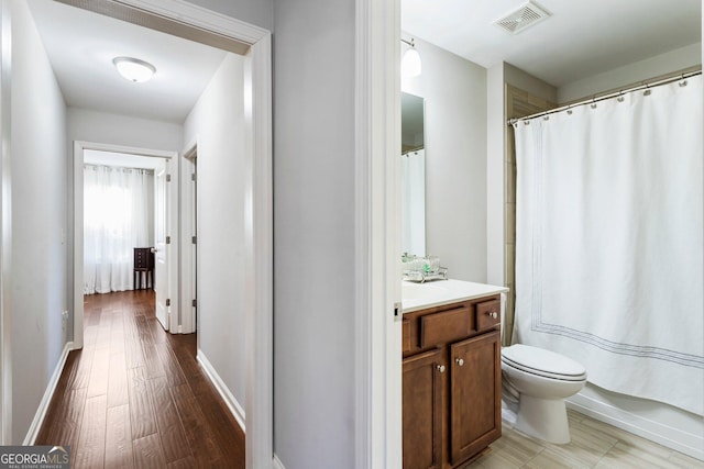 bathroom with hardwood / wood-style flooring, toilet, and vanity