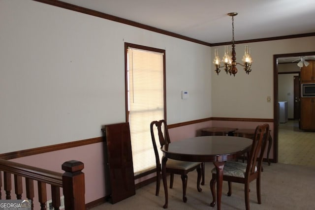 dining space with a chandelier, light colored carpet, and crown molding