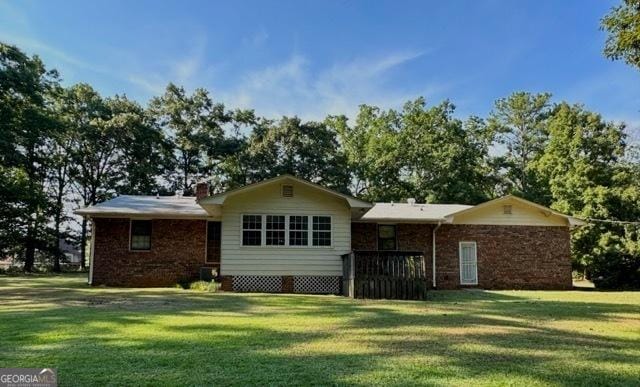 single story home featuring a chimney and a front yard