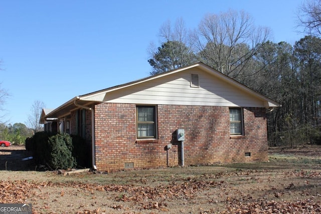 view of property exterior with crawl space and brick siding