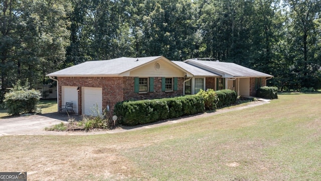 view of property exterior with a garage, brick siding, a yard, and driveway