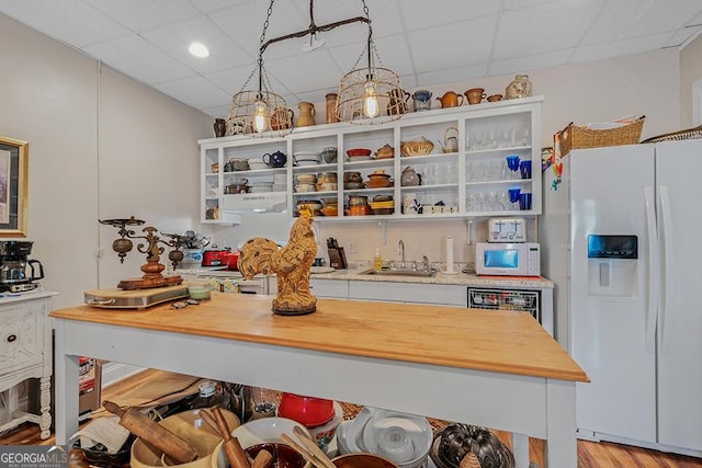 kitchen with decorative light fixtures, a drop ceiling, sink, and white appliances