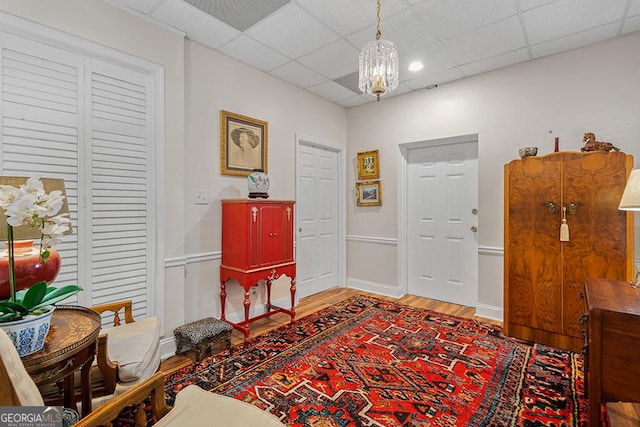 entrance foyer with a paneled ceiling, a chandelier, and hardwood / wood-style floors