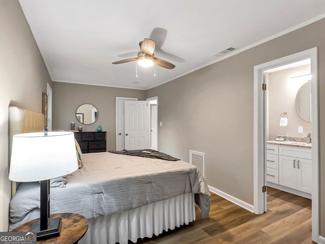 bedroom featuring ceiling fan, ornamental molding, ensuite bathroom, and hardwood / wood-style floors