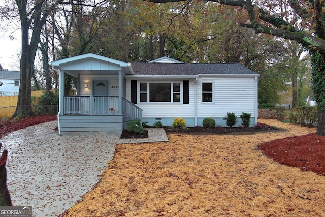 ranch-style home featuring crawl space, covered porch, and a shingled roof