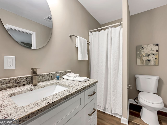 full bathroom featuring vanity, wood finished floors, visible vents, baseboards, and toilet