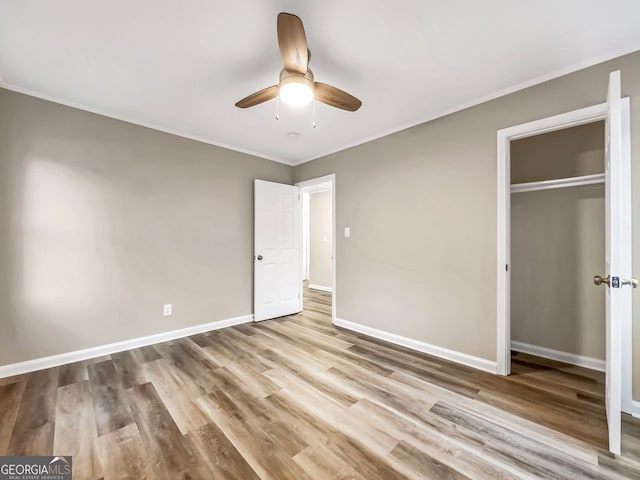 unfurnished bedroom featuring ceiling fan, a closet, ornamental molding, and light hardwood / wood-style floors