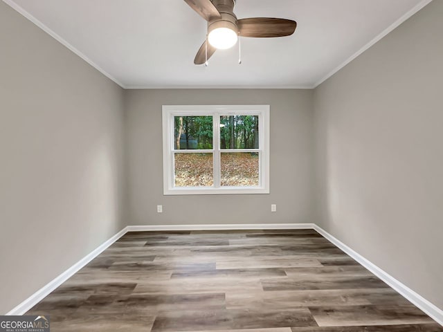empty room featuring ornamental molding, ceiling fan, baseboards, and wood finished floors