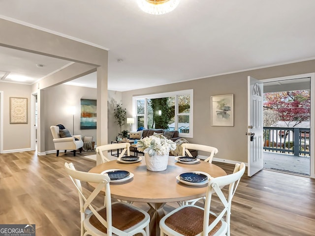 dining area with light wood finished floors, baseboards, and ornamental molding